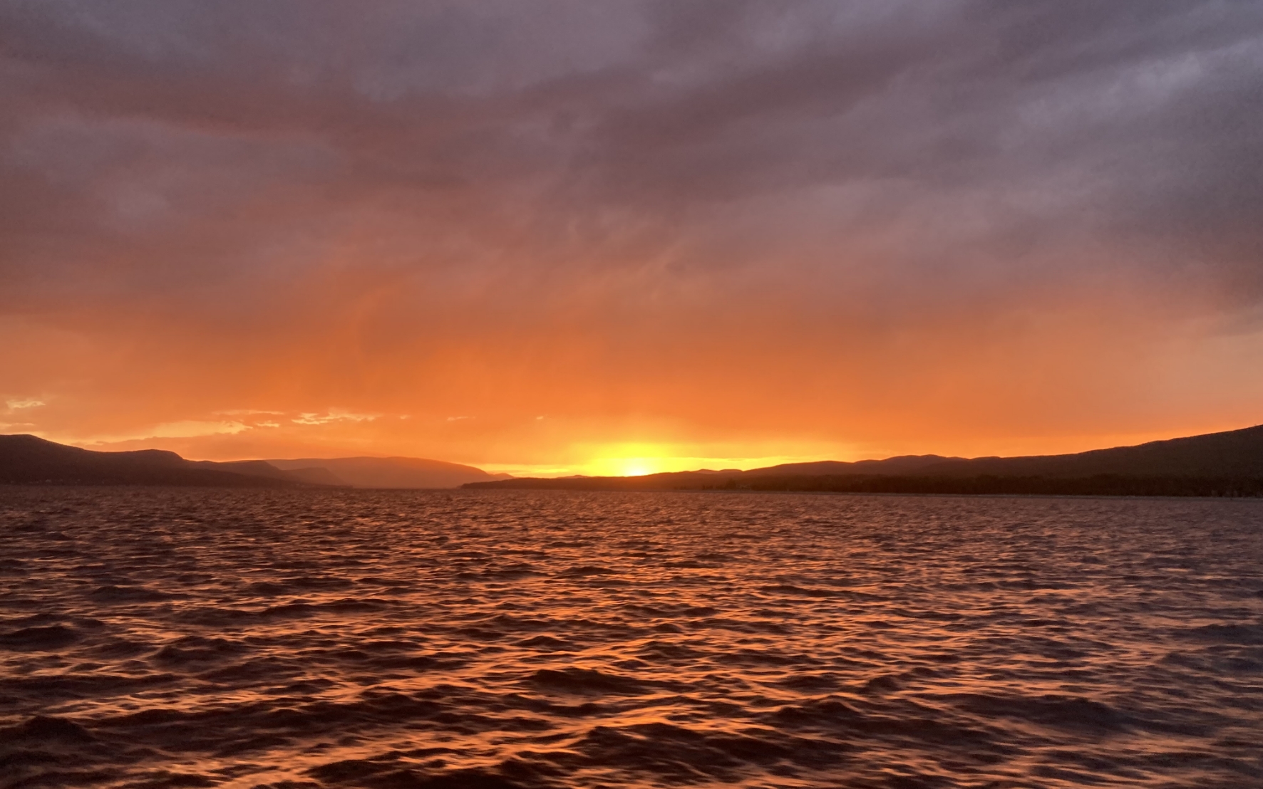 Coucher de soleil flamboyant sur le golfe du Saint-Laurent avec les montagnes de la Gaspésie à l’horizon